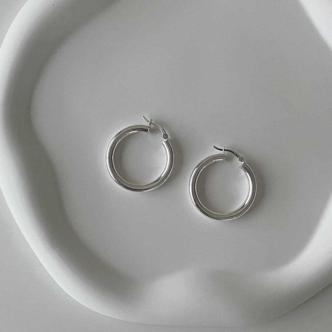 CHESI 925 sterling silver Classic Tube Hoops in 30mm laid on a tray.