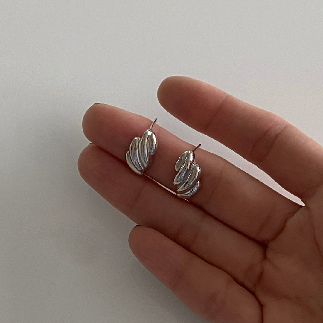 CHESI 925 sterling silver Croissant Studs on model's hand.