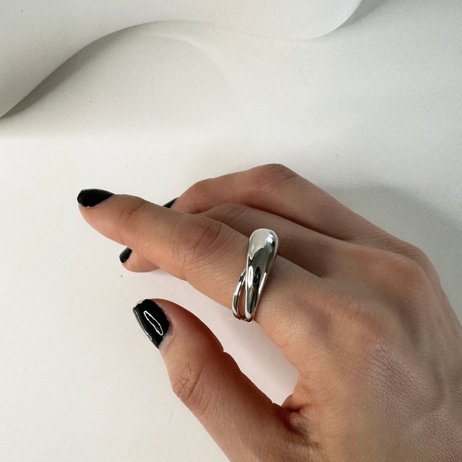 Adjustable CHESI Dome Cut Out Ring in 925 sterling silver with rhodium plating, worn on female model's hand.