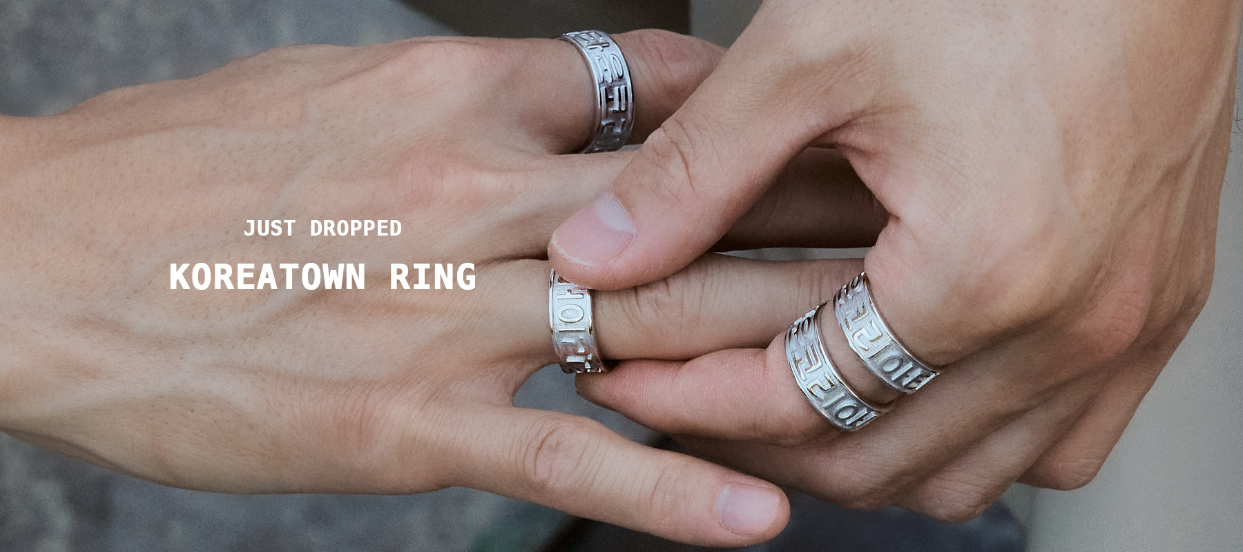 close-up of male model’s hands wearing multiple CHESI 925 sterling silver Koreatown rings.