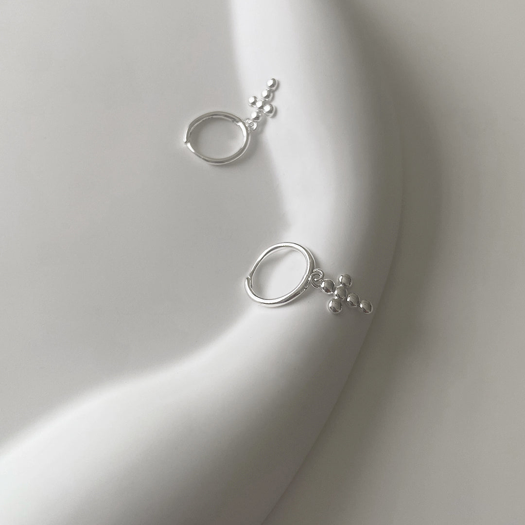 CHESI 925 sterling silver Mini Bubble Cross Earrings angle view on white tray.