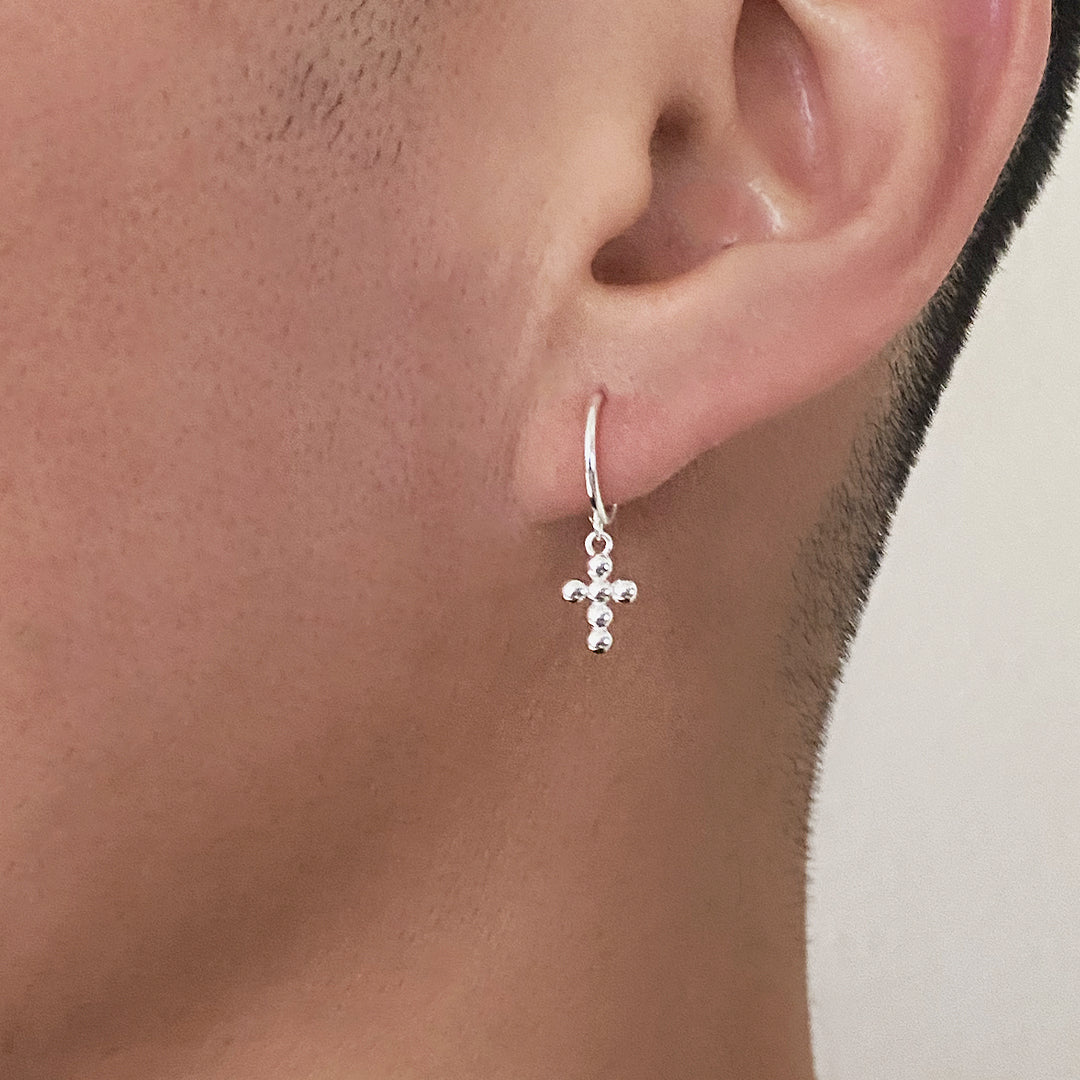 Male model wearing CHESI 925 sterling silver Mini Bubble Cross Earrings.