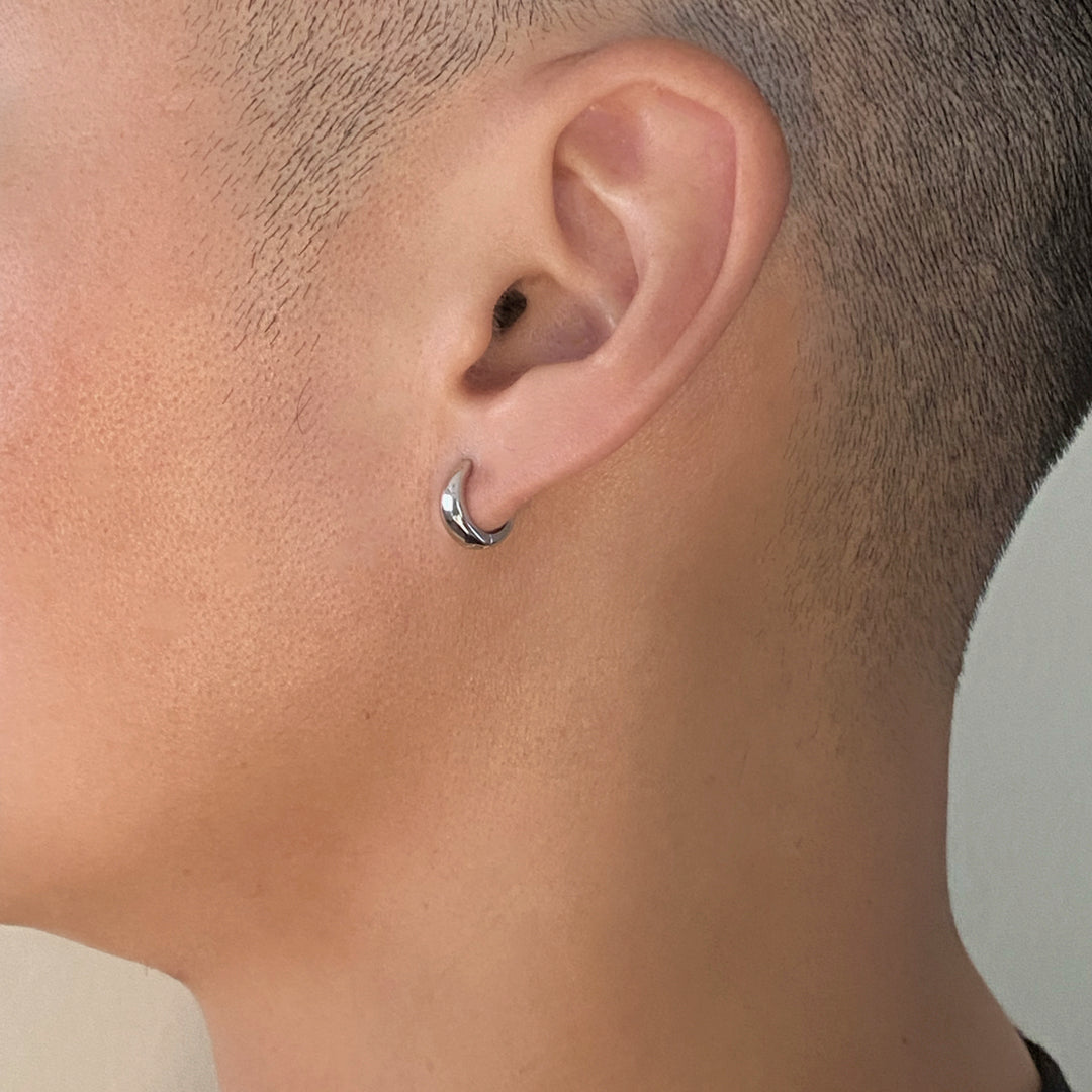 Male model wearing CHESI 925 sterling silver Mini Chunky Huggies with rhodium plating.