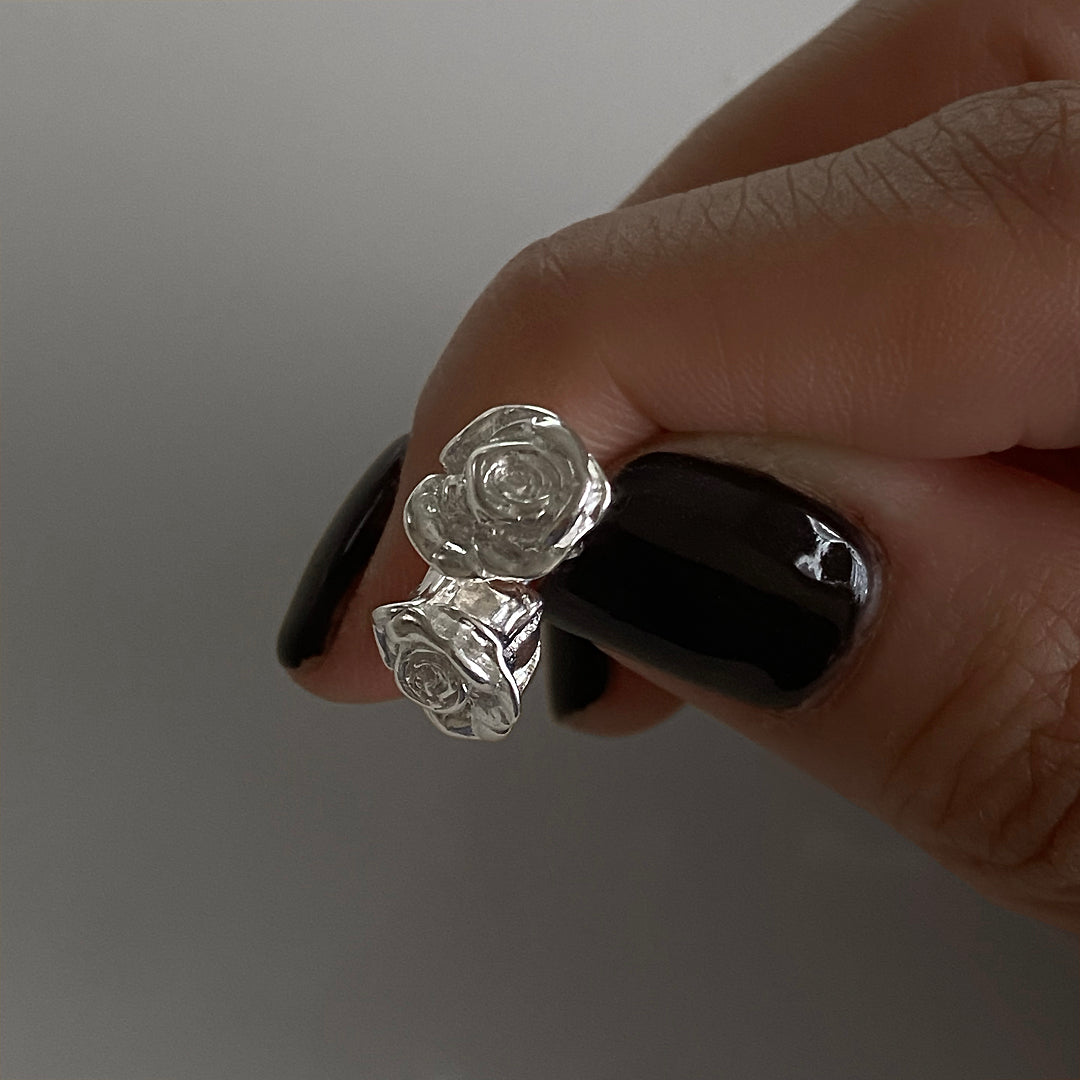 Close-up detail of CHESI Rosy Stud Earrings in 925 sterling silver, held by model.