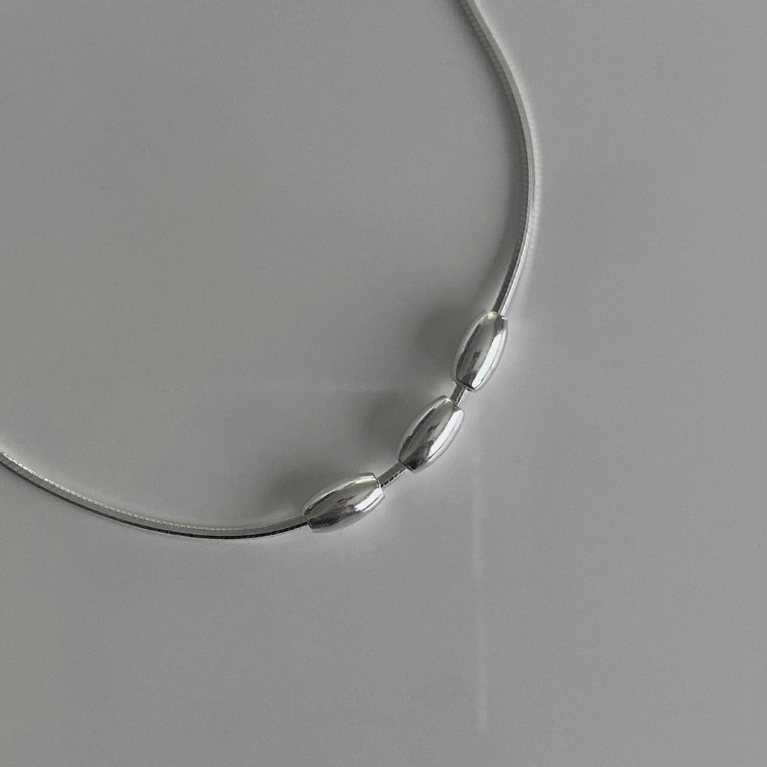 CHESI Triple Charm Necklace in 925 sterling silver, close-up of three bead details from an angle.