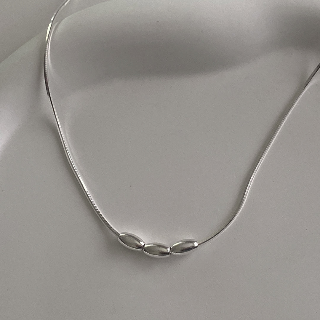 Close-up of CHESI 925 sterling silver Triple Charm Necklace showing three small beads on a box snake chain.