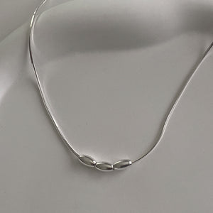 Close-up of CHESI 925 sterling silver Triple Charm Necklace showing three small beads on a box snake chain.