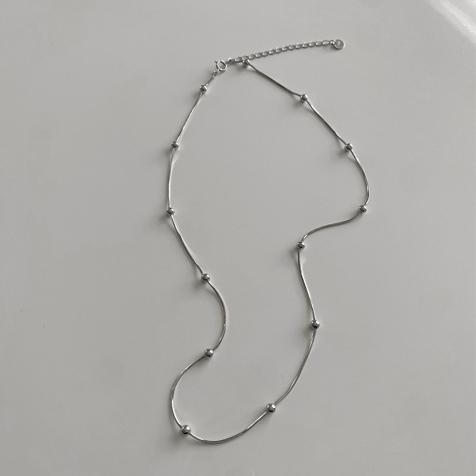 Top view of CHESI 925 sterling silver Dainty Beaded Necklace with extended chain for closure.